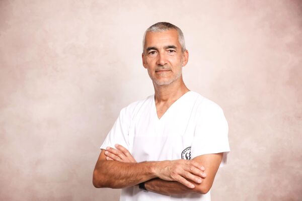 O Osteopata Semeão, de braços cruzados, na clínica
